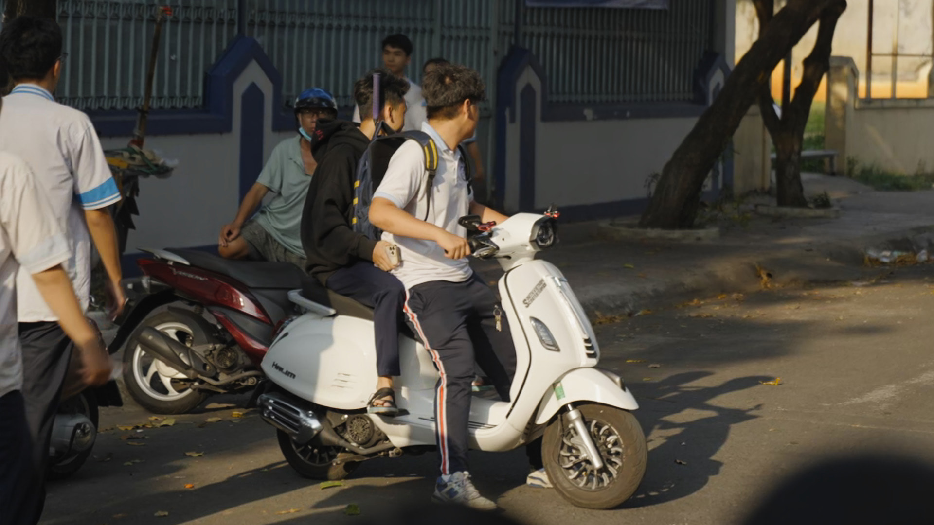Học sinh đi xe máy điện không đội mũ bảo hiểm